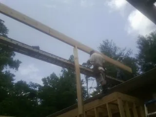 Carpenter setting a ridge beam over a new addition frame — Ice Dam Removal by Roofing Brothers in Edisto Island