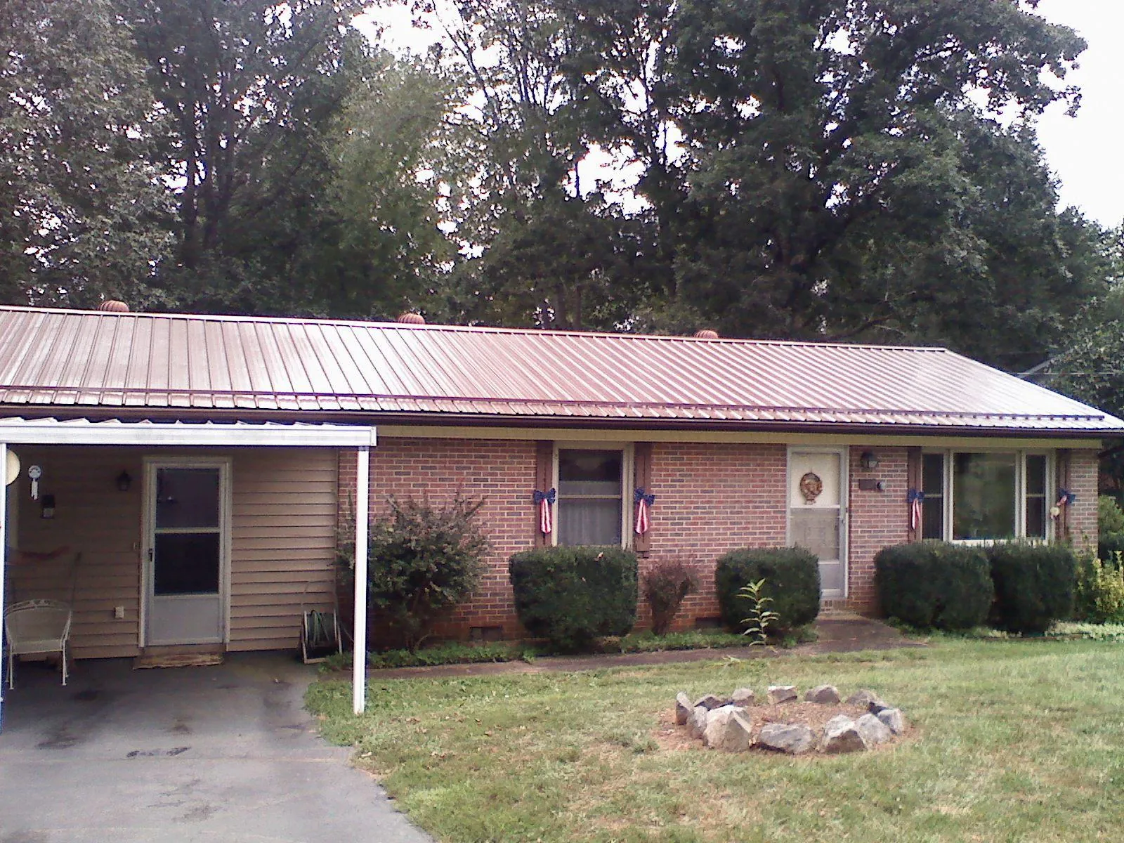 Bronze metal roof and carport on a brick ranch home — Roof Repair work by our crew in Edisto Island